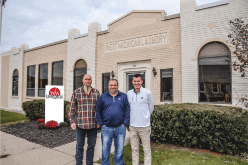 Three men standing in front of their business